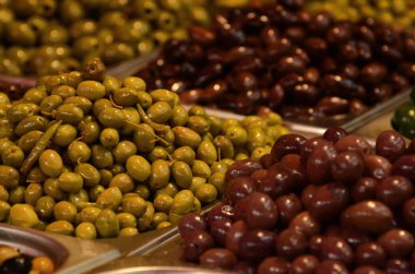 Salamura edilmiş zeytinlerin iştah açıcı çeşitleri. Tel Aviv 'de bir markette yeşil ve siyah zeytin. Büyük, güzel zeytin turşusu..
