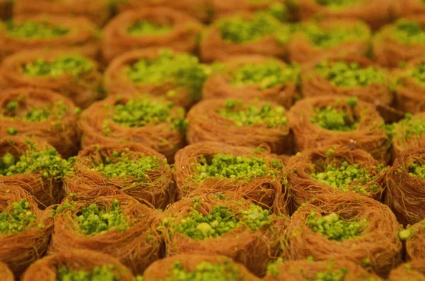 Turkish baklava. Eastern market, counter. Arabic dessert made from honey and syrup. Oriental sweets with peanuts, almonds and pistachio nuts