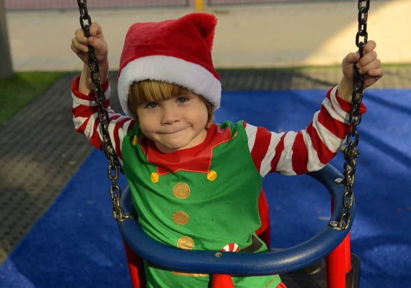 Dziecko Kapeluszu Świętego Mikołaja Huśtawce Chłopiec Placu Zabaw — Zdjęcie stockowe