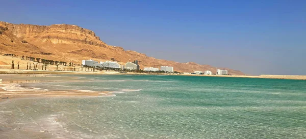 stock image Ein Bokek resort on the Dead Sea in Israel. The majestic mountains of the Judean Desert, the snow-white buildings of luxury hotels, the turquoise sea and salt mushrooms.