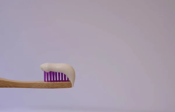 Houten Tandenborstel Met Witte Tandpasta Achtergrond Een Plumeria Bloem Concept — Stockfoto