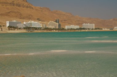 İsrail 'deki Ölü Deniz kıyısındaki Ein Bokek tatil köyü. Musevi Çölü 'nün görkemli dağları, lüks otellerin kar beyazı binaları, turkuaz deniz ve tuz mantarları..