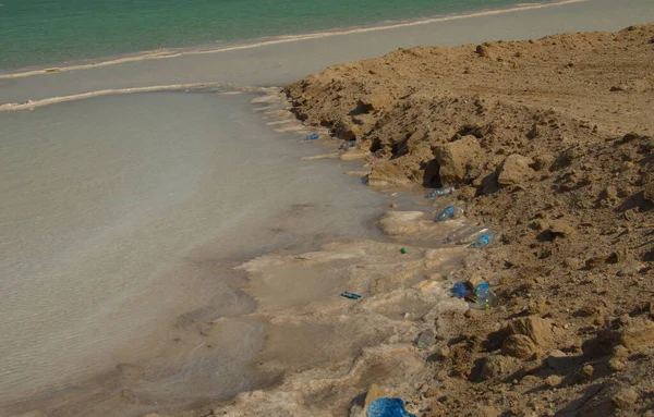 Coasts of the Dead Sea in the Judean Desert, salt and plastic. Plastic trash in a unique healing salt lake. Ecological disaster, garbage island. Plastic in the world\'s oceans.