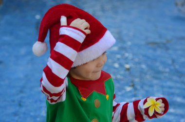 Havuzun ya da fıskiyenin arkasında Noel Baba şapkalı şirin bir çocuğun portresi. Kavram: Tropikal Noel, kış yolculuğu, kışın yaz.. 