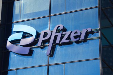 Israel Marina Herzliya. Kasım 2022. Modern bir binanın camında Pfizer Şirketi logosu. Ofis ve marka adı. Koronovirüs ve hastalıklara karşı aşı üretme laboratuvarı.