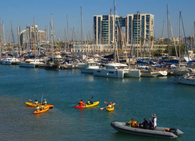 Israel Marina Herzliya. Kasım 2022. Çocuklar kanoyu nasıl kontrol edeceklerini öğrenirler. Yüzme dersleri, kaptanlar okulu, yelkenli tekneler. Kürekli bir kanodaki çocuklar, bottaki yetişkin gözlemciler.