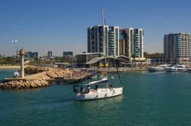 İsrail. Herzliya Kasım 2022. Yat Marina. Yelkenlideki mürettebat. Erkekler düğüm ve çamurluk örer. Skipper yelkenliyle seyahat ediyor, deniz tatili, kira ve yat kiralama.