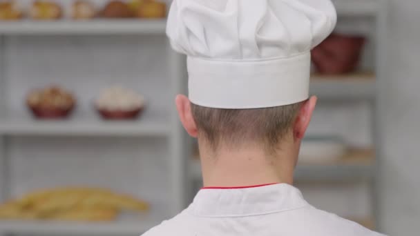 Chef Dans Une Casquette Avec Dos Chef Regarde Les Étagères — Video