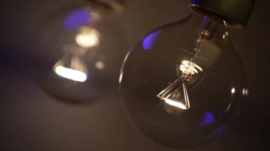 Karanlıkta iki ampul yanıyor ve sönüyor. Tesla ampulü. Elektriksel yakın çekim. Enerji sistemi, ışık, elektrik kesintisi.