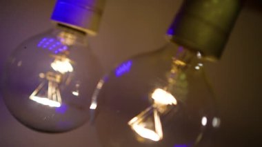 Karanlıkta iki ampul yanıyor ve sönüyor. Tesla ampulü. Elektriksel yakın çekim. Enerji sistemi, ışık, elektrik kesintisi.