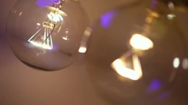 Karanlıkta iki ampul yanıyor ve sönüyor. Tesla ampulü. Elektriksel yakın çekim. Enerji sistemi, ışık, elektrik kesintisi.