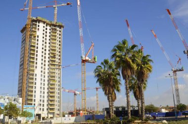Yarasa Yam. İsrail. Aralık 2022. Yüksek katlı bir konut inşaatı. Yeni binalar, vinçler, palmiye ağaçları. İsrail 'de gayrimenkul. Daire binaları.