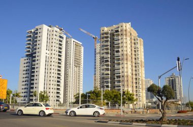 Rishon Lezion. İsrail. Aralık 2022. Emlak ve yeni binalar. Yeni yerleşim alanları, palmiye ağaçları, portakal ağaçları, otoyollar. İnşaat vinci, inşaat alanı.