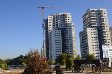 Rishon Lezion. İsrail. Aralık 2022. Emlak ve yeni binalar. Yeni yerleşim alanları, palmiye ağaçları, portakal ağaçları, otoyollar. İnşaat vinci, inşaat alanı.