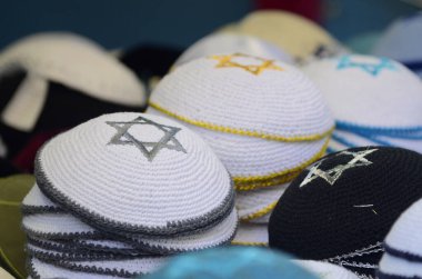Siyah beyaz ve yıldız David geleneksel Yahudi kipa yığınları. Kippah kelimelerle pazarda satılmak için dua ediyor.. 