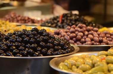 Demir kasede zeytinler, yakın plan. Zeytin çeşitliliği, siyah, yeşil, mor