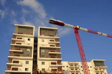 Güzel bir manzara. İnşaat alanı. Beyaz bina ve kırmızı inşaat vinci. Mesaj için yer var. İsrail 'de gayrimenkul. Ev almak, ipotekli bir daire, krediyle.