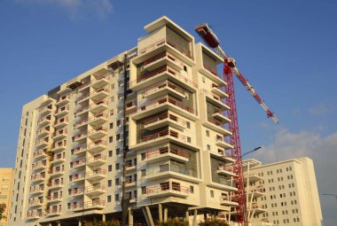 Güzel bir manzara. İnşaat alanı. Beyaz bina ve kırmızı inşaat vinci. Mesaj için yer var. İsrail 'de gayrimenkul. Ev almak, ipotekli bir daire, krediyle.