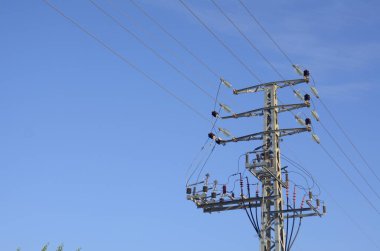 Yüksek voltaj direkleri, sokak elektrik hatları. Yakın plan. Kavram: enerji tasarrufu, güneş panelleri, elektrik faturaları.