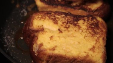 Toast in an egg is fried in a pan with butter. Thickly sliced white bread. Fried bread, hot sandwich.Top view shot of cooking process. Easy breakfast recipe from bread 