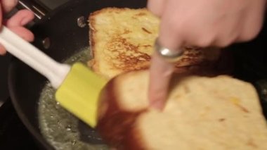 Toast in an egg is fried in a pan with butter. Thickly sliced white bread. Fried bread, hot sandwich.Top view shot of cooking process. Easy breakfast recipe from bread 