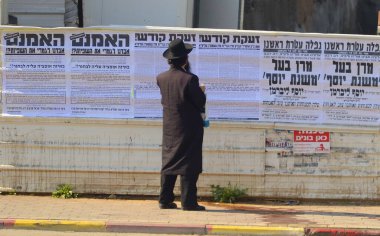 Religious Jewish man in a traditional black hat with sidelocks. Haredim - view from the back Bnei Brak Israel January 2023