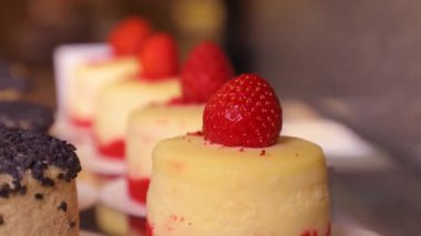 Cream cake with strawberries. Showcase in the bakery. Dessert in assortment in a coffee shop