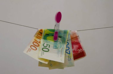 Yeni İsrail şekeli - 50, 100 ve 200 'lük banknotlar. Mandalda asılı kağıt para. Kavram: vergi, kara para aklama, yolsuzluk, enflasyon, maaş,