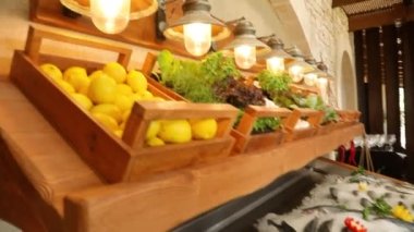 Showcase with fresh fish in a restaurant. Dorado and sea bass in ice, decorated with fruits. Counter with fish, seafood