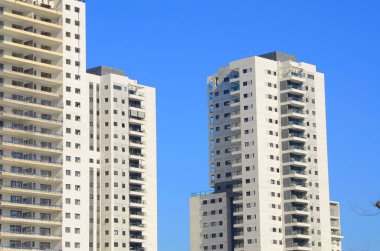 Beautiful white residential buildings. Modern area, new buildings. Real estate in Israel. Tenement house Tall new residential buildings against the sky, space for text