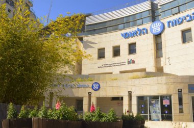 Logo Bituah Leumi. The hand holds money, new Israeli shekel. payments to Bituach Leumi. Israeli national social services. Translate: National Insurance Institute . Holon Israel February 2023