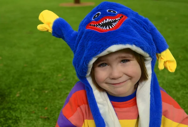 Purim, Cadılar Bayramı. Kulakları olan komik şapkalı sevimli çocuk. Bir çocuğun gülümsemesi, neşeli bir ruh hali. Karnaval kostümü giymiş bir çocuk. Şenlikli başlıklı bir çocuğun portresi.