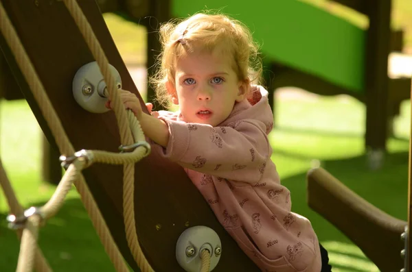 Sweet girl, blonde, 3 years old laughs. Girl on the playground