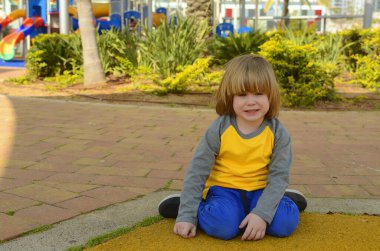 Positive boy 4 years old at the playground. Bright playground, palm trees, good mood. The face of the child, positive emotions