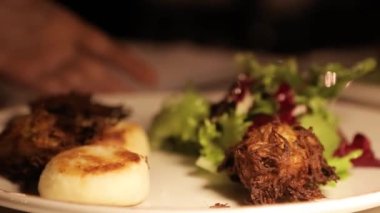 A dish in a restaurant, cheese pancakes and fried artichokes with lettuce. Fresh healthy vegan food. 