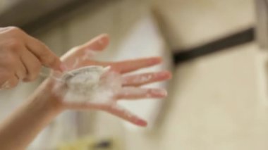 Flour strainer, female hands close-up, sifting flour on freshly baked bread. Sprinkling with flour