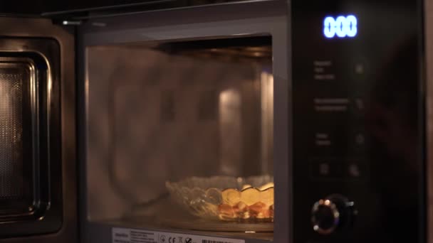 Man Lägger Mat Mikrovågsugnen För Att Värma Upp Halvfabrikat Snabbmat — Stockvideo