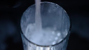Musluktan temiz içme suyu. Ağır çekim. Bir bardak su, güzel bir çerçeve. Kavram: susuzluk, tasarruf kaynakları, su kullanımı, kamu hizmeti fiyatları, sifonu çekme.