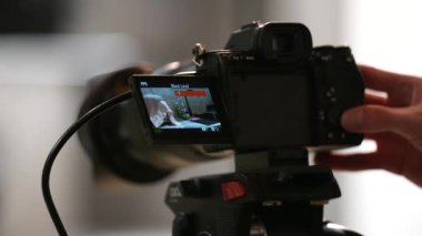 Konsept: video yapımı. Kameraman Sony Alpha kamerasını çekim için ayarlıyor. Kontrol monitörü, tripodun üzerindeki kamera. Ukrayna. Kyiv. Mart 2023