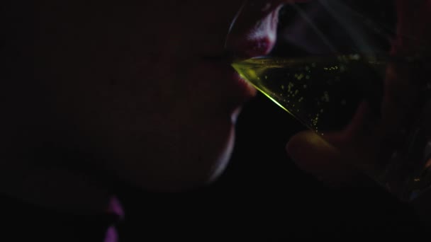 人的脸在黑暗中 一个人喝着杯子里的黄色液体 那家伙喝柠檬水 喝能量饮料 — 图库视频影像