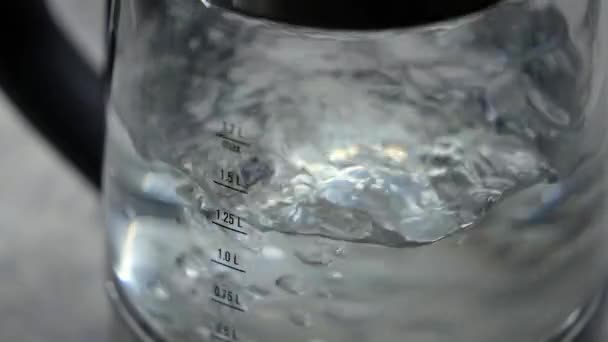 電気ガラスケトルは水を沸かす 測定列 水の量 スローモーションティーポット 沸騰プロセス ゴボゴボというお湯 ティーポット照明 — ストック動画