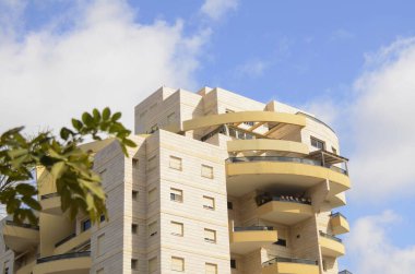 Modern bir apartmanda balkon, jöleli teras. Yakınlarda güzel bir çiçek ağacı var. Pencerenin altındaki bahçe.