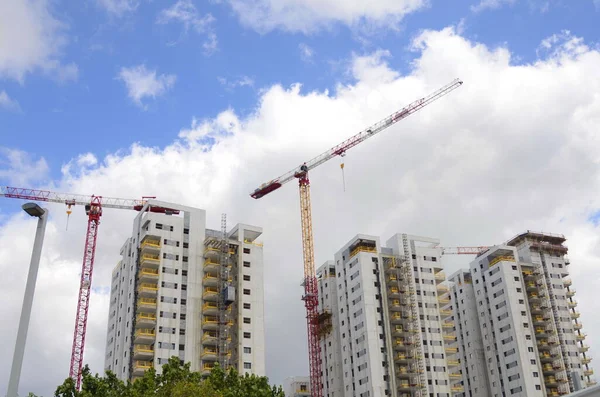 Construction crane, construction of a residential high-rise building. Real estate in Israel. Investment, mortgage, loan, purchase. High-rise buildings, high-rise cranes.