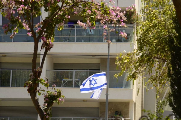 stock image Independence Day in the State of Israel. The streets are decorated with flags. Patriotism. Modern house, glass balconies. real estate in israel.