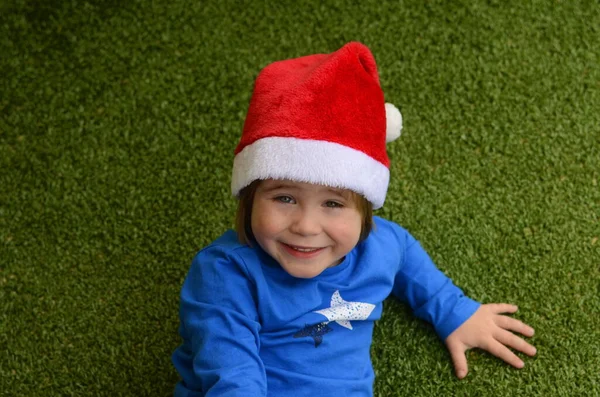 Chłopiec Kapeluszu Mikołaja Zielonym Tle Dziecko Leży Podłodze Portret Uśmiechniętego — Zdjęcie stockowe