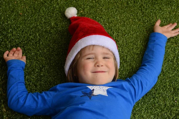 Chłopiec Kapeluszu Mikołaja Zielonym Tle Dziecko Leży Podłodze Portret Uśmiechniętego — Zdjęcie stockowe