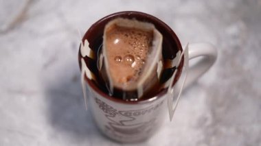 Kahve poşetini ıslatır, cam bardakta kahve yapar. Kapat.