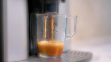 Kahve makinesi Americano kahvesi doldurur. Kremalı kahve. Yakın çekim, ağır çekim 4 km şeffaf büyük kupa.