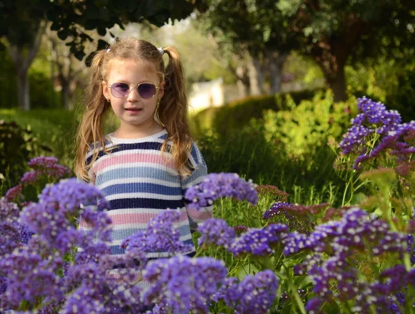 在公园散步的时候 一个漂亮的女孩戴着两个戴着太阳镜的马尾辫 6岁女童的肖像 — 图库照片