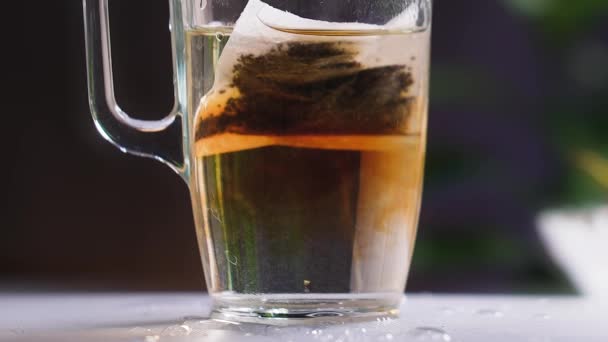 Uma Caneca Transparente Mesa Com Água Fervente Saco Chá Dissolve — Vídeo de Stock